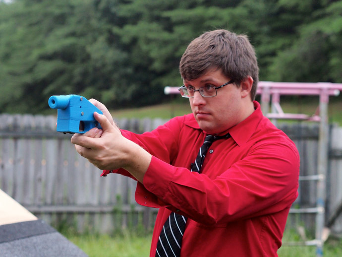 Software engineer Travis Lerol takes aim with an unloaded Liberator handgun in the backyard of his home on July 11, 2013. (AFP Photo/Robert MacPherson)