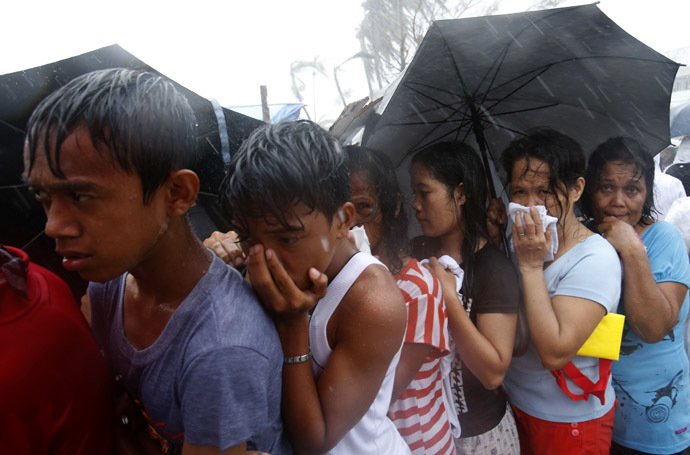 Victims queue for food and water during a heavy downpour in the aftermath of super typhoon Haiyan in Tacloban city, central Philippines - November 14, 2013. (Reuters)