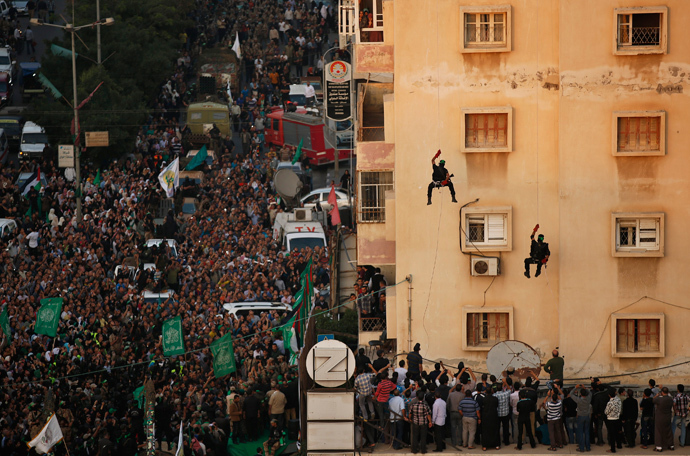 Palestinians look at Hamas militants as they rappel down a building during a military parade marking the first anniversary of the eight-day conflict with Israel, in Gaza City November 14, 2013. (Reuters / Mohammed Salem)