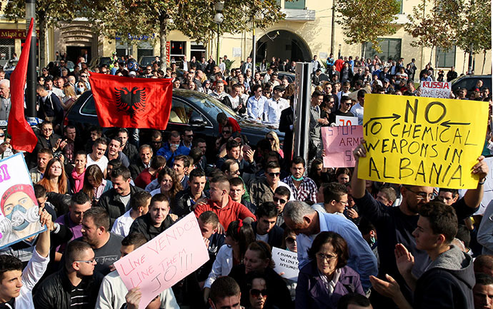 Albanian environmental activists hold up national flags and signs as they take part in a protest in front of the Albanian parliament in Tirana on November 14, 2013, over the possibility of the Republic of Albania processing and destroying 1.000 tons of chemical weapons from Syria in its military facilities. (AFP Photo)