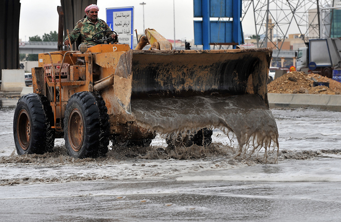 A Saudi labourer tries to clear a flooded street in northern Riyadh, on November 17, 2013, after heavy rains fell overnight in the Saudi capital, causing floods and traffic jams and forcing the Saudi Eduction Ministry to suspend studies in schools and universities for one day (AFP Photo / Fayez Nureldine)