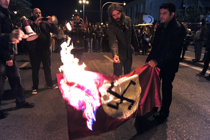 Leftist students burn a Nazi flag in front of the US embassy in Athens, during a march commemorating the 1973 students uprising against the military junta. Tens of thousands marched in Greece on November 17 (AFP Photo / Louisa Gouliamaki) 