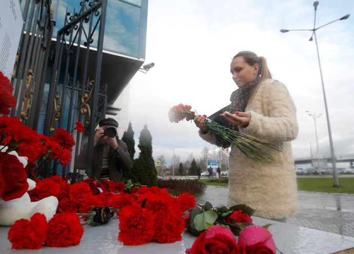 A woman lays flowers near a fence of Kazan airport, where a Tatarstan Airlines Boeing 737 crashed, November 18, 2013 (Reuters / Maxim Shemetov)