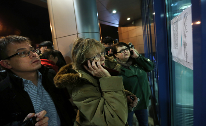 Relatives read lists of killed passengers inside of the main building of Kazan airport on November 17, 2013. (AFP Photo / Roman Kruchinin)