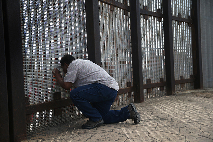 Family members reunite through bars and mesh of the U.S.-Mexico border fence at Friendship Park on November 17, 2013 in San Diego, California. (AFP Photo / John Moore)