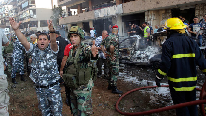 A soldier (in green, 2nd L) and policeman gesture at the site of the explosions near the Iranian embassy in Beirut November 19, 2013.(Reuters / Mahmoud Kheir)