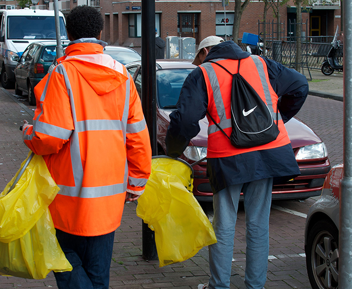 Chronic alcoholics clean a street in Amsterdam. (AFP Photo / Nicolas Delaunay)