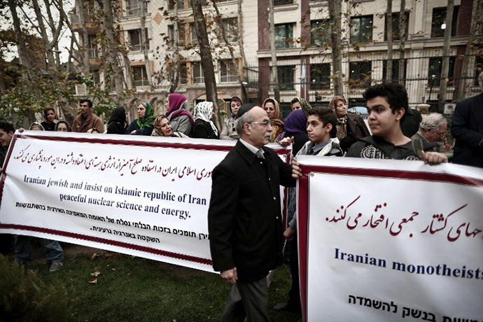 Iranian Jews hold banners as they attend a demonstration in front of the United Nation's building in Tehran on November 19, 2013 in support of Iran's nuclear program and Iranian negotiators on the eve of the new round of nuclear talks with world powers in Geneva. (AFP Photo / Behrouz Mehri)