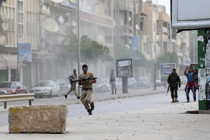 A member of the Libyan army runs with a weapon during clashes between members of Islamist militant group Ansar al-Sharia and a Libyan army special forces unit in the Ras Obeida area in Benghazi November 25, 2013. (Reuters/Esam Omran Al-Fetori)