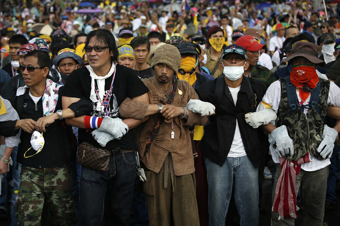 Anti-government protesters link their arms as they get ready to attack a police barricade near the Government house in Bangkok November 25, 2013. (Reuters/Damir Sagolj)