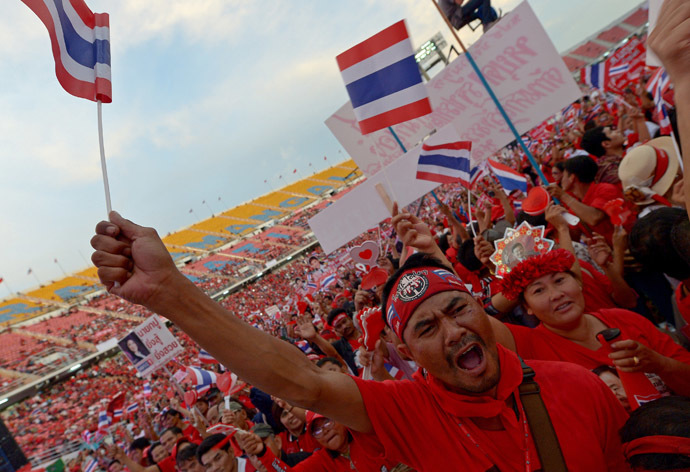 Thai pro-government "Red Shirts" wave national flag as they gather at Rajamangala stadium in Bangkok on November 24, 2013. (AFP Photo)