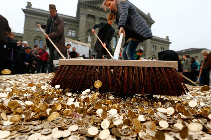Committee members use brooms to spread out five cent coins over the Federal Square during an event organised by the Committee for the initiative "CHF 2,500 monthly for everyone" (Grundeinkommen) in Bern October 4, 2013.(Reuters / Denis Balibouse)