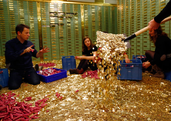 Committee members for the initiative "CHF 2,500 monthly for everyone" (Grundeinkommen) open rolls of five cent coins in the old vault of the former Schweizerische Volksbank in Basel October 1, 2013.(Reuters / Ruben Sprich)
