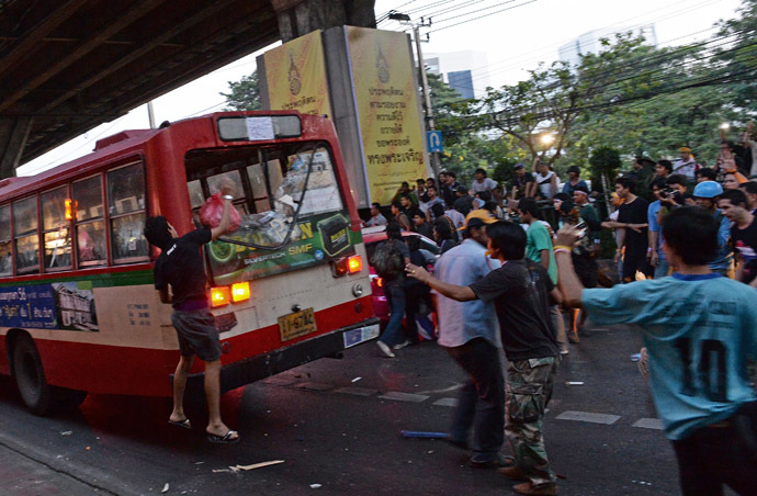 Thai opposition protesters attack a bus carrying pro-government Red Shirt supporters on their way to a rally at a stadium in Bangkok on November 30, 2013.(AFP Photo/Christophe Archambault)