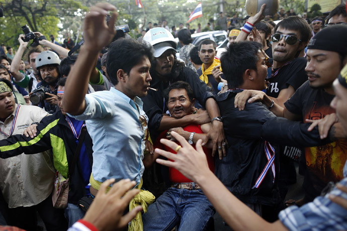 A man is attacked by anti-government protesters near the stadium where pro-government red shirts are gathering in Bangkok November 30, 2013. (Reuters/Damir Sagolj)