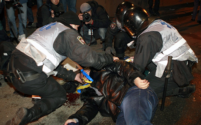 An injured man receives medical help from Interior Ministry members during a rally held by supporters of EU integration in Kiev, December 1, 2013. (Reuters / Gleb Garanich)