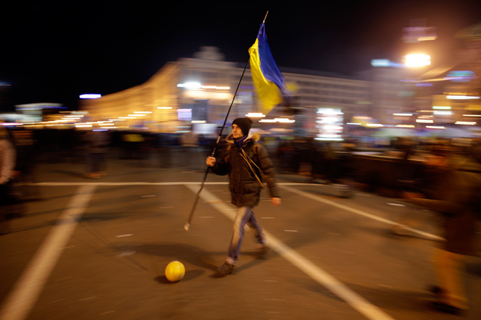 A protester holding a Ukrainian flag plays soccer during a rally at Independence Square in Kiev December 2, 2013. (Reuters / Stoyan Nenov)