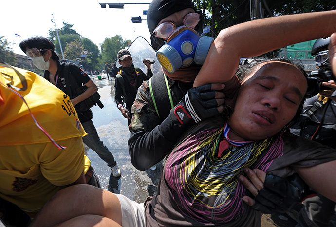 Volunteers carry an injured anti-government protester during a demonstration at the Government House in Bangkok on December 2, 2013. (AFP Photo / Pornchai Kittiwongsakul)