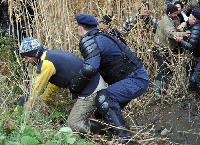 Romanian gendarm scuffle with local people during a protest against shale gas exploition in Pungesti village in Romania on October 16, 2013. (AFP Photo/Adrian Arnautu)