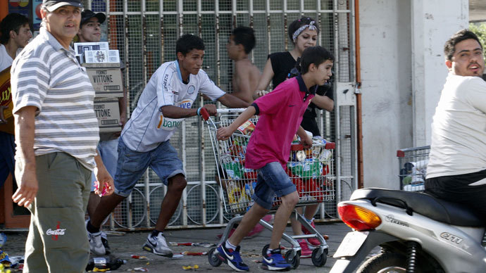 Looters leave a supermarket in Cordoba, Argentina, on December 3, 2013.(AFP Photo / STR)