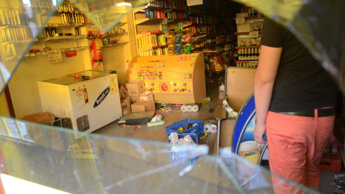 Workers clean a looted a supermarket on December 03, 2013 in Cordoba.(AFP Photo / Irma Montiel)