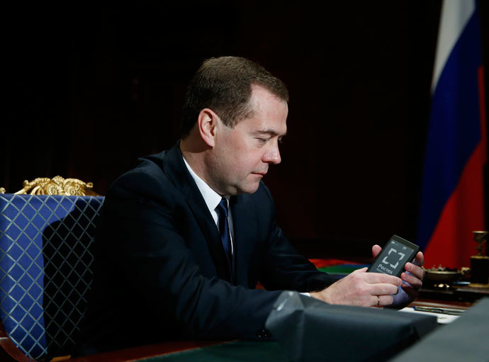 Russia's Prime Minister Dmitry Medvedev holds a YotaPhone smartphone during a meeting with Sergei Chemezov, CEO of Rostec State Corporation, at the Gorki residence outside Moscow, December 4, 2013.(Reuters / Dmitry Astakhov)