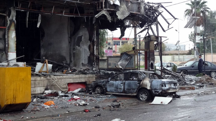 A picture taken on December 5, 2013 shows damages and a burnt vehicle after the mall in the northern Iraqi city of Kirkuk was stormed by security forces to end an hours-long siege that has followed an attack involving a car bomb, gunmen and would-be suicide bombers.(AFP Photo / Marwan Ibrahim)