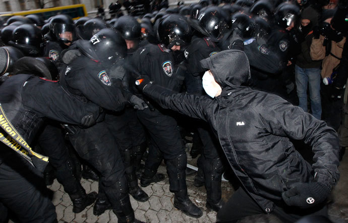  man sprays gas as Interior Ministry members stand guard during a rally held by supporters of EU integration in Kiev, December 1, 2013.(Reuters / Vasily Fedosenko)