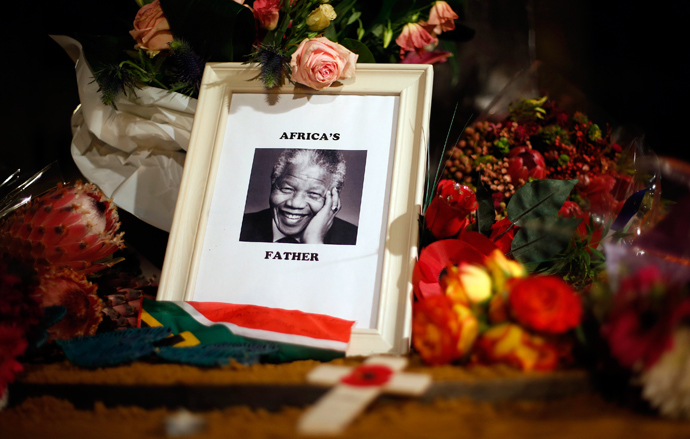 Flowers and tributes are left on the Nelson Mandela statue on Parliament Square in London December 6, 2013. (Reuters / Suzanne Plunkett) 