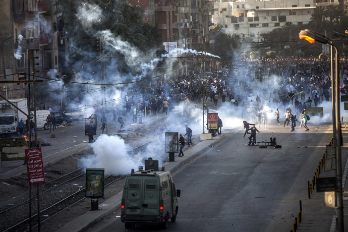 Muslim Brotherhood and ousted president Mohammed Morsi supporters (background) clash with Egyptian riot police during a demonstration in the streets of El Zeitun neighborhood close by al Qubba presidential Palace on December 6, 2013 in Cairo. (AFP Photo/Mahmoud Khaled)