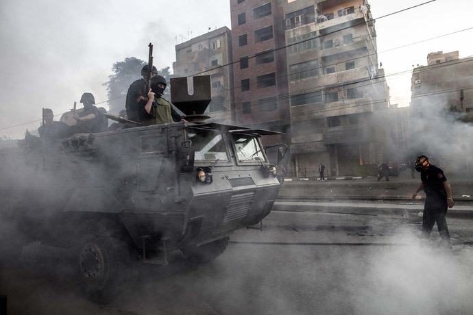 Egyptian security forces patrol on an armoured vehicle during clashes following a demonstration of Muslim Brotherhood and ousted president Mohammed Morsi supporters on December 6, 2013 in the streets of El Zeitun neighborhood close by al Qubba presidential Palace in Cairo. (AFP Photo/Mahmoud Khaled)