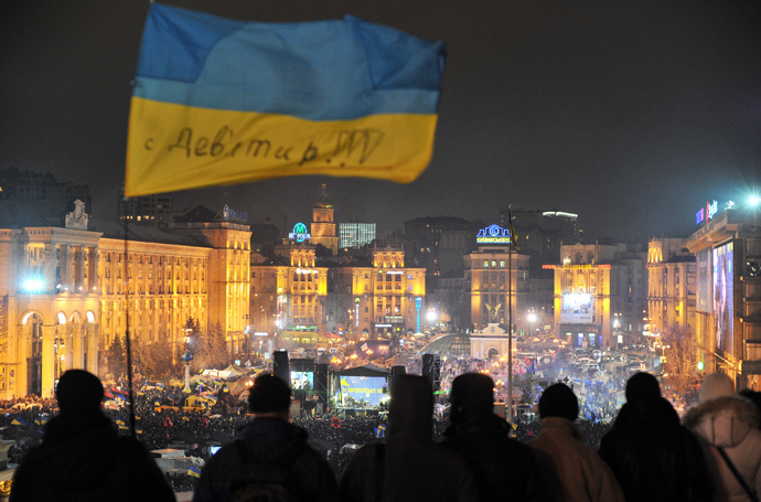 Protesters fly a Ukrainian flag above Independence Square in central Kiev as people gather for an opposition rally on December 17, 2013 (AFP Photo / Genya Savilov)