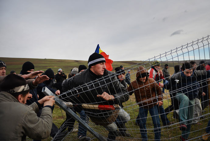 Romanian protesters tear down the fence of the exploring perimeter of US energy giant Chevron in Pungesti, Romania on December 7, 2013. (AFP Photo / Daniel Mihailescu)