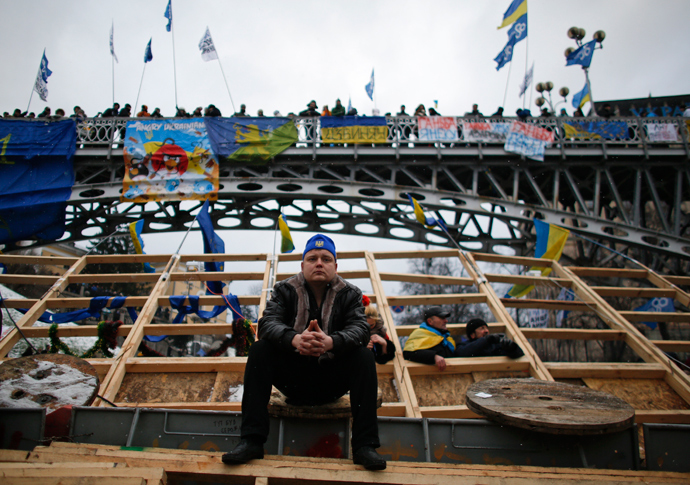 A man sits on a barricade during a rally organized by supporters of EU integration in central Kiev, December 8, 2013 (Reuters / Stoyan Nenov)