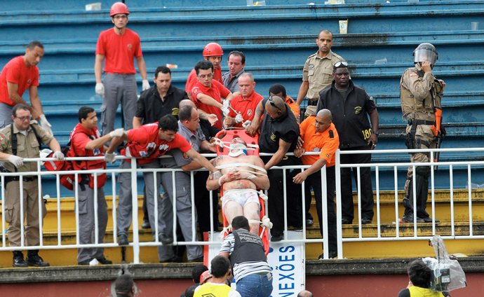 Paramedics use a stretcher to carry an injured Atletico Paranaense fan after clashes between fans of Vasco da Gama and Atletico Paranaense during their Brazilian championship match in Joinville in Santa Catarina state December 8, 2013.(Reuters / Carlos Moraes / Agencia O Dia)