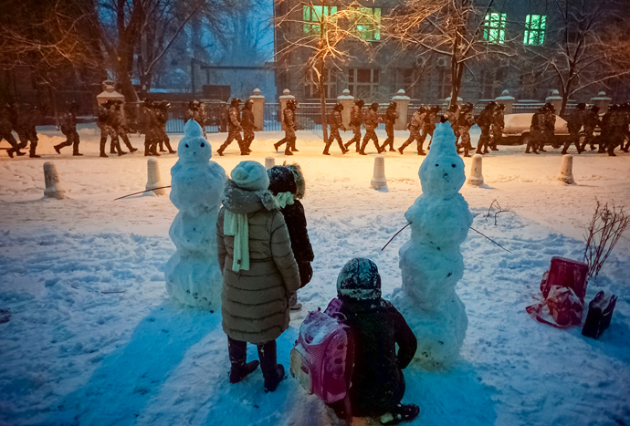 Children look on as riot police go to block a street near the presidential administration building during a gathering of supporters of EU integration in Kiev, December 9, 2013 (Reuters / Mykhailo Petiakh)