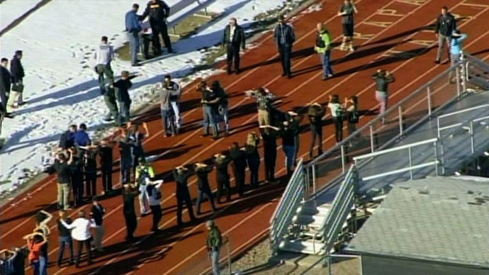 In this framegrab taken from video by KCNC television news in Denver, students of Arapahoe High School in Centennial, Colorado, line up to be checked by police at a running track on December 13, 2013 after a shooting at the school. (AFP Photo / KCNC)