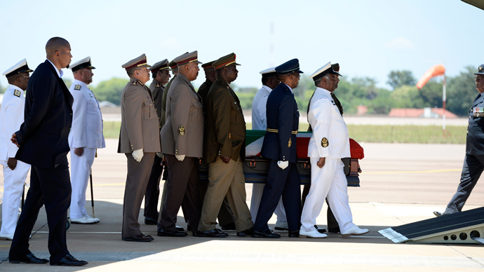 The coffin of South African former president Nelson Mandela is carried by officers as Mandela's grandson Mandla (2L) looks on after a Farewell Service on December 14, 2013 at the Waterkloof air force base in Pretoria before its departure to Mthatha (AFP Photo / Stephane De Sakutin)