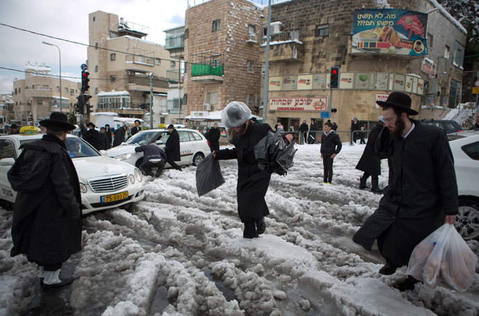 Ultra-orthodox Jews walk in a street of Jerusalem on December 13, 2013 following a snowstorm.(AFP Photo / Menahem Kahana)