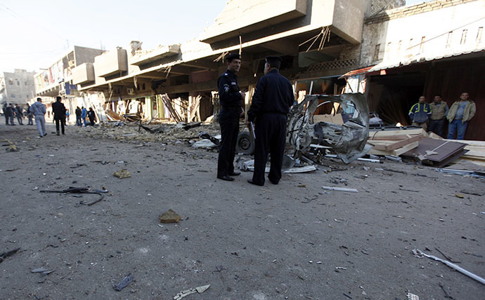Iraqi policemen inspect the site of car bomb attack in Baghdad December 16, 2013. (Reuters / Ahmed Saad)
