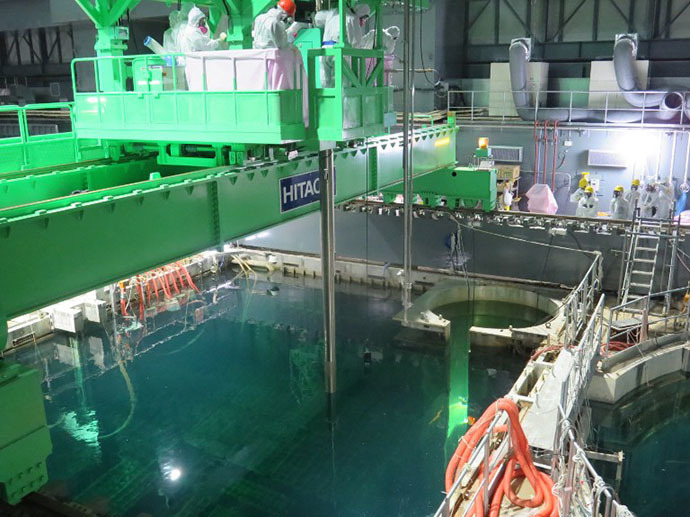 This handout picture taken by Tokyo Electric Power Co (TEPCO) on November 18, 2013 shows an operation of nuclear fuel being lifted and moved by TEPCO workers as TEPCO started operation to remove fuel rods from a pool at the unit four reactor building of TEPCO's Fukushima Dai-ichi nuclear plant in the town of Okuma in Fukushima prefecture. (AFP Photo)