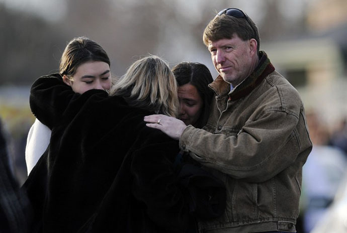 Family and friends comfort each other outside Shepherd of the Hills Church after a school shooting at Arapahoe High School on December 13, 2013 in Centennial, Colorado. (AFP Photo / Chris Schneider)