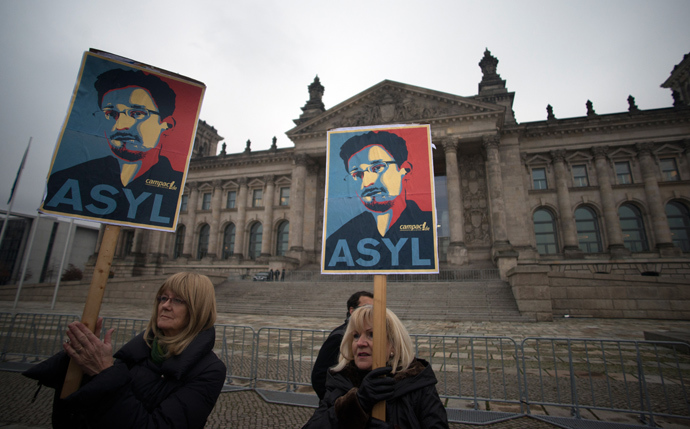 Protesters hold up pictures of US whistleblower Edward Snowden in front of the Reichstag building housing the Bundestag (lower house of parliament) in Berlin on November 18, 2013 (AFP Photo / Johannes Eisele)