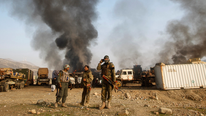 Afghan security forces stand near burning NATO supply trucks after what police officials say was an attack by militants in the Torkham area near the Pakistani-Afghan border in Jalalabad Province December 18, 2013 (Reuters / Parwiz)