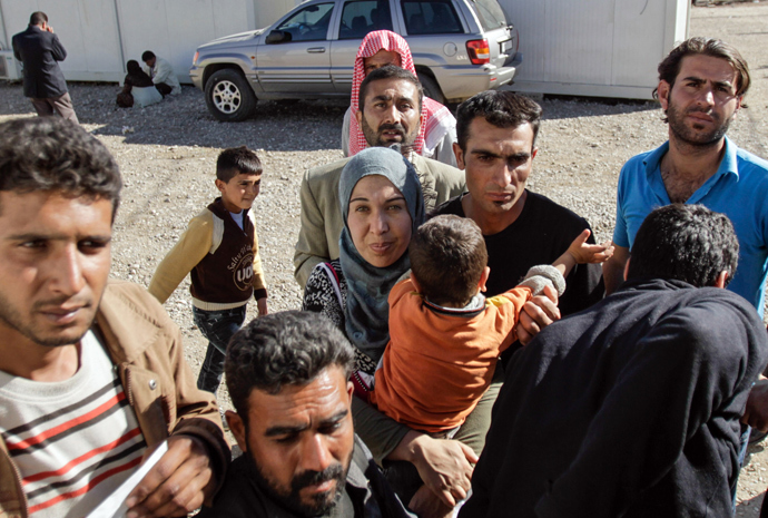 Syrian Kurd refugges wait for permission from the Kurdish Committees for the Protection of the Kurdish People (YPG), who control a crossing into neighboring Iraq, close to the town of Semalka, in northeast Syria (AFP Photo / Mauricio Morales) 