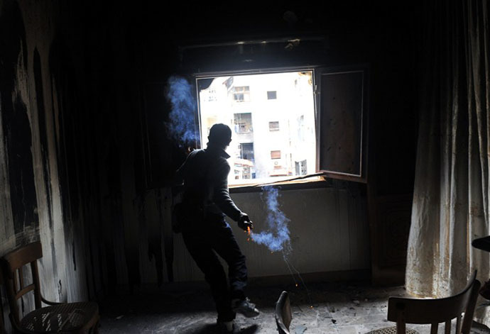(FILES) A rebel fighter throws a homemade grenade towards Syrian government forces through a window at a flat in the Salaheddine neighbourhood of Aleppo (AFP Photo / Bulent Kilic)