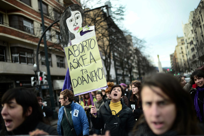 A demonstrator carries a sign reading "Costless And Free Abortion" during a pro-choice protest against the government's proposed new abortion law in Bilbao, December 21, 2013. (Reuters/Vincent West)