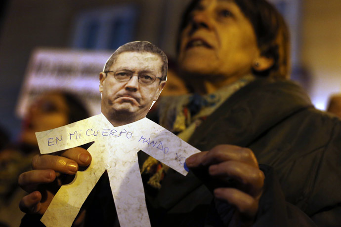 A demonstrator holds a paper cut-out bearing the image of Spanish Justice Minister Alberto Ruiz Gallardon with the words "I rule over my body" written on it during a pro-choice protest against the government's proposed new abortion law in Madrid, December 20, 2013. (Reuters/Susana Vera)