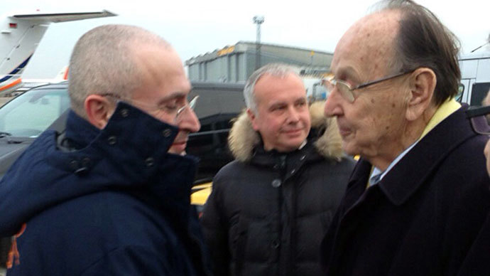 Russian former oil tycoon and Kremlin critic Mikhail Khodorkovsky (L) shaking hands with former German foreign minister Hans-Dietrich upon arrival at Schoenefeld airport in Berlin on December 20, 2013.(AFP Photo / khodorkovsky.ru)
