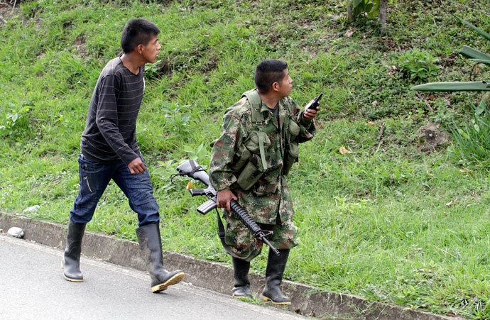 A member of the Revolutionary Armed Forces of Colombia (FARC) walks with his gun in the mountains of Caldono, Cauca province June 4, 2013.(Reuters / Jaime Saldarriaga)